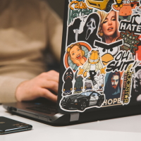 The back of a laptop, covered in personal stickers