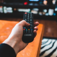 A hand holding a remote pointed into the distance